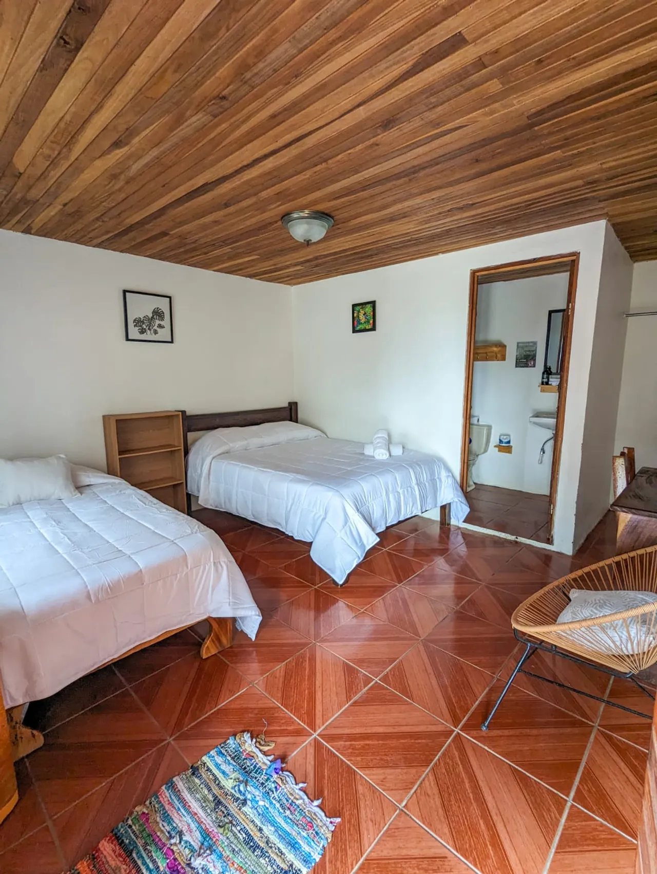 Habitación doble con baño privado y silla acapulco