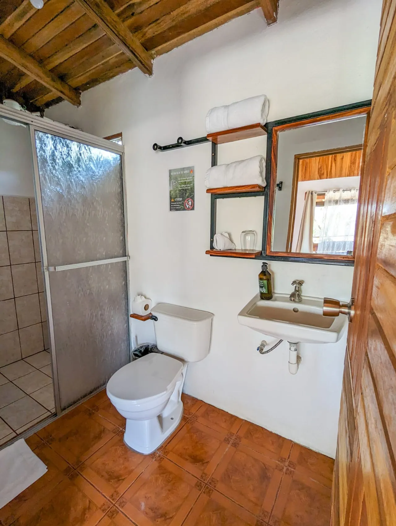 Baño privado con ducha y espejo de madera