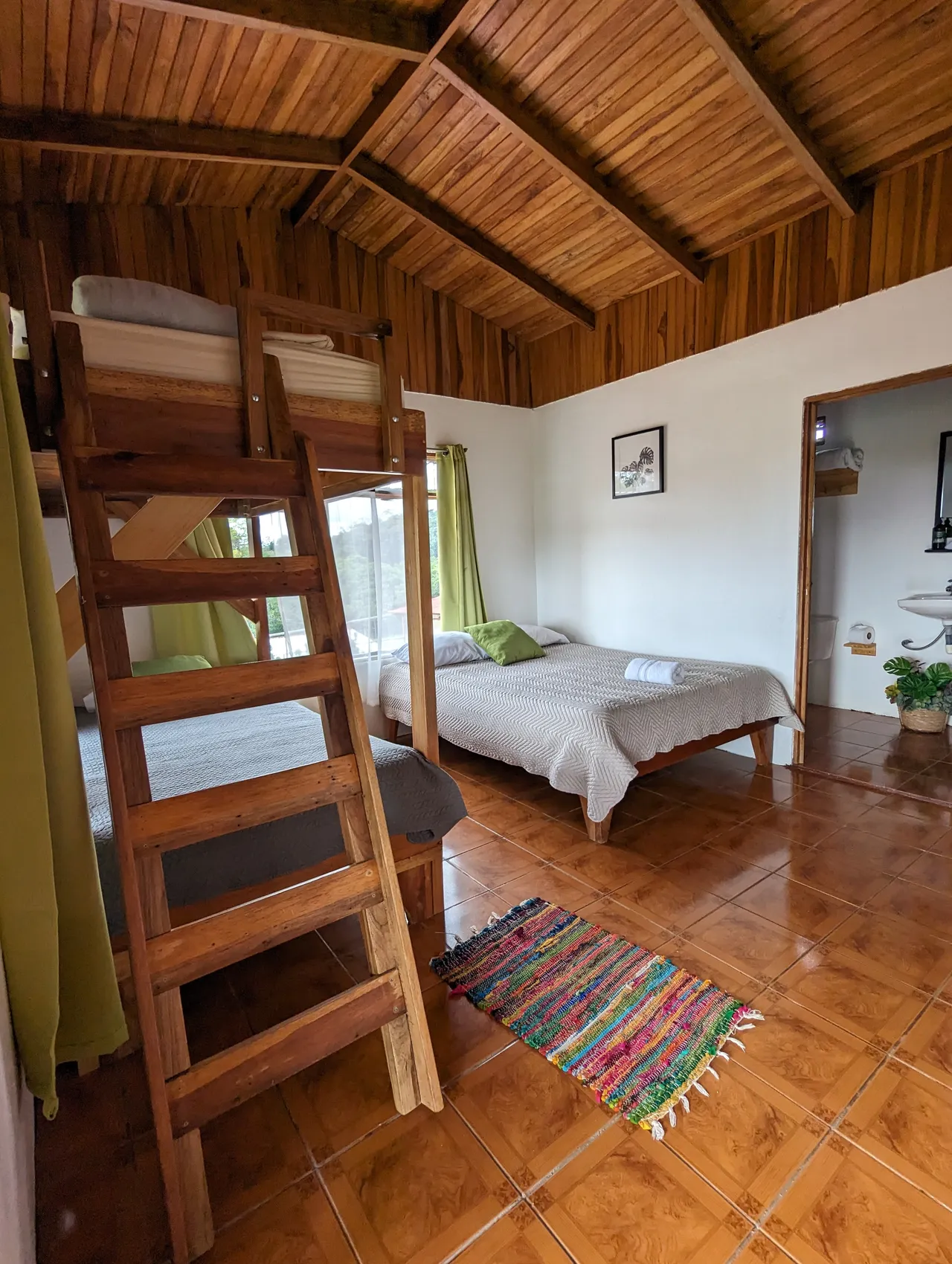 Habitación con cama alta con escalera y cama matrimonial
