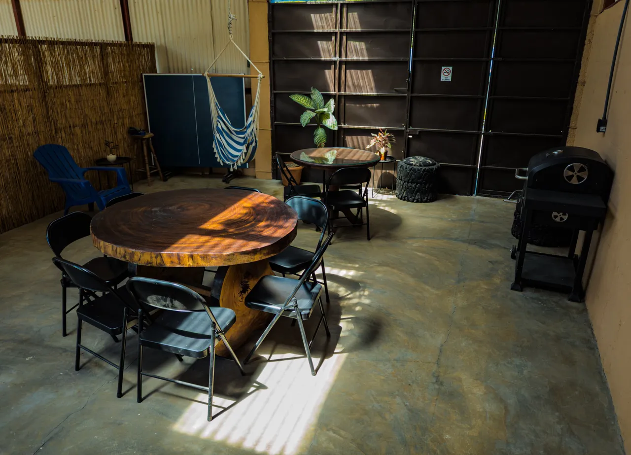 Área social con mesas, hamaca, mesa de ping pong y parrilla